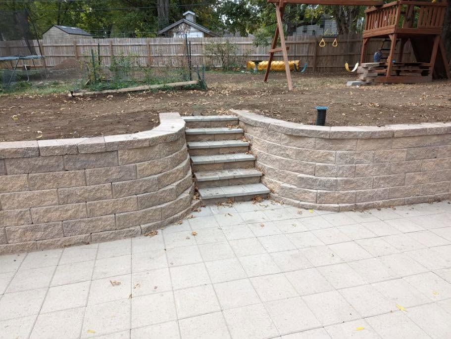 Finished retaining wall with paver patio and steps